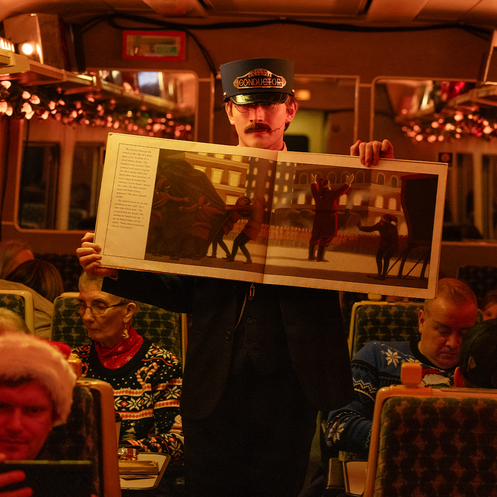 Conductor with book on board THE POLAR EXPRESS™ Train Ride